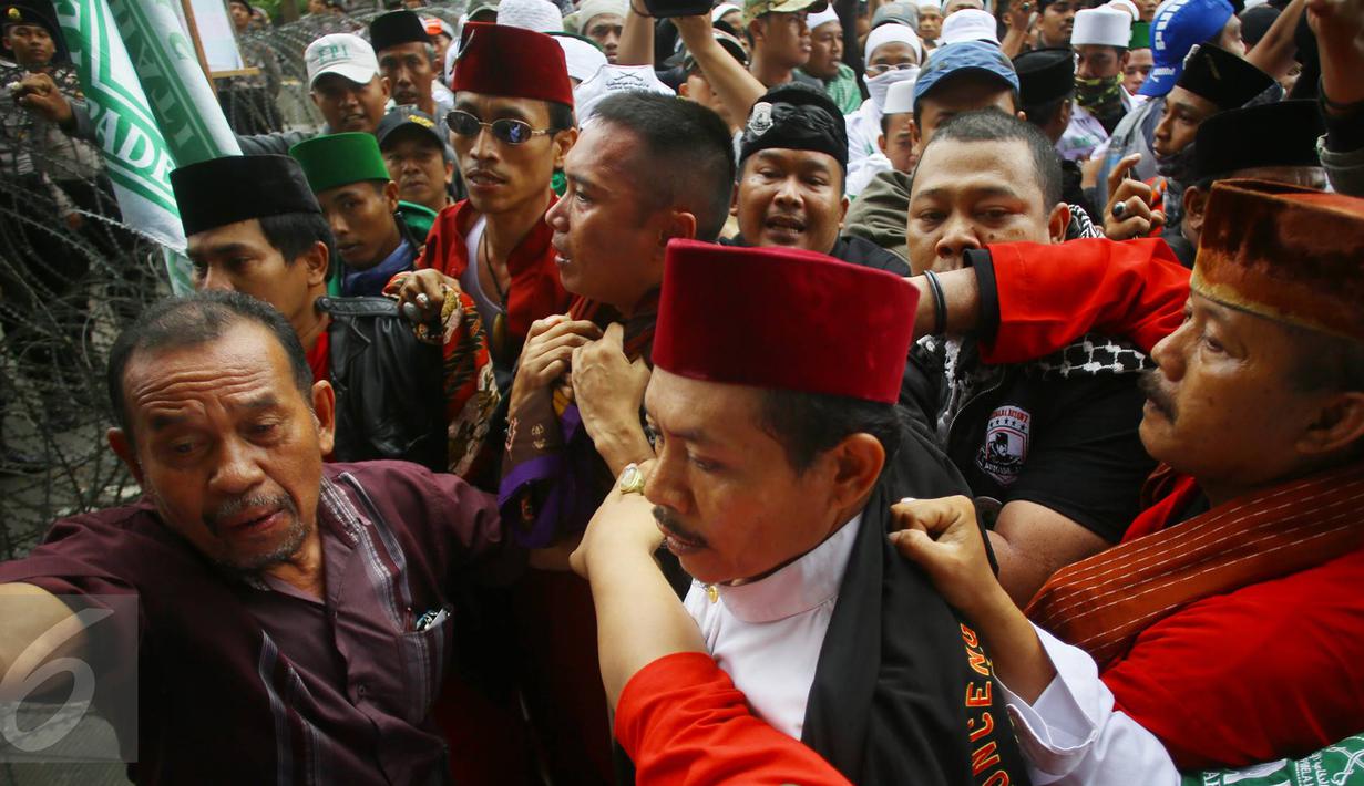 Massa mengamankan seorang pria yang diduga provokator saat sidang kasus penistaan agama di Jakarta, Selasa (10/1). Sempat terjadi kericuhan akibat peristiwa tersebut. (Liputan6.com/Immanuel Antonius)