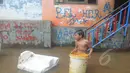 Seorang anak terlihat bermain banjir yang melanda kawasan Kampung Pulo, Jatinegara, Jakarta Timur, Selasa (10/2/2015). (Liputan6.com/Herman Zakharia)