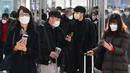 Orang-orang yang memakai masker berjalan di stasiun kereta api Seoul, setelah Korea Selatan mencabut mandat masker dalam ruangan, Senin (30/1/2023). Namun, mandat masker akan tetap berlaku di fasilitas berisiko tinggi seperti panti jompo, rumah sakit, apotek, dan transportasi umum. (Jung Yeon-je / AFP)