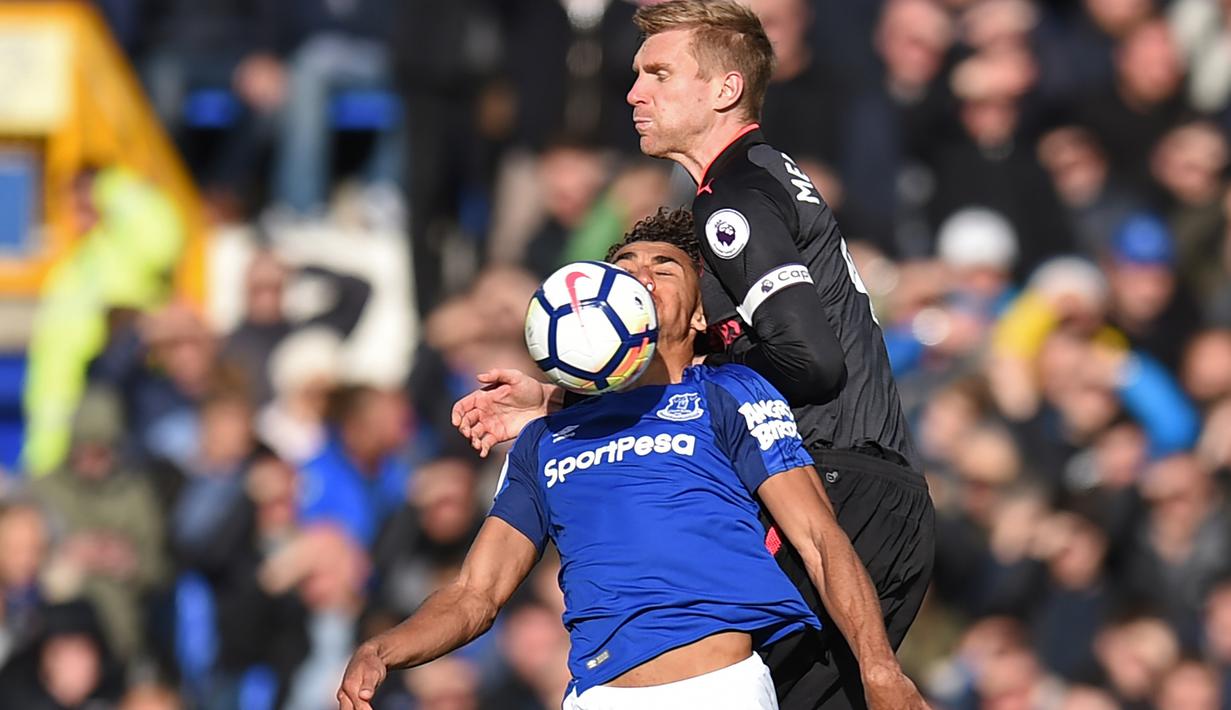 Pemain Everton,  Dominic Calvert-Lewin (kiri) berebut bola dengan pemain Arsenal, Per Mertesacker (kanan) pada laga Premier League pekan ke-9 di Goodison Park, Liverpool, (22/10/2017). Arsenal menang 5-2. (AFP/Oli Scarff)