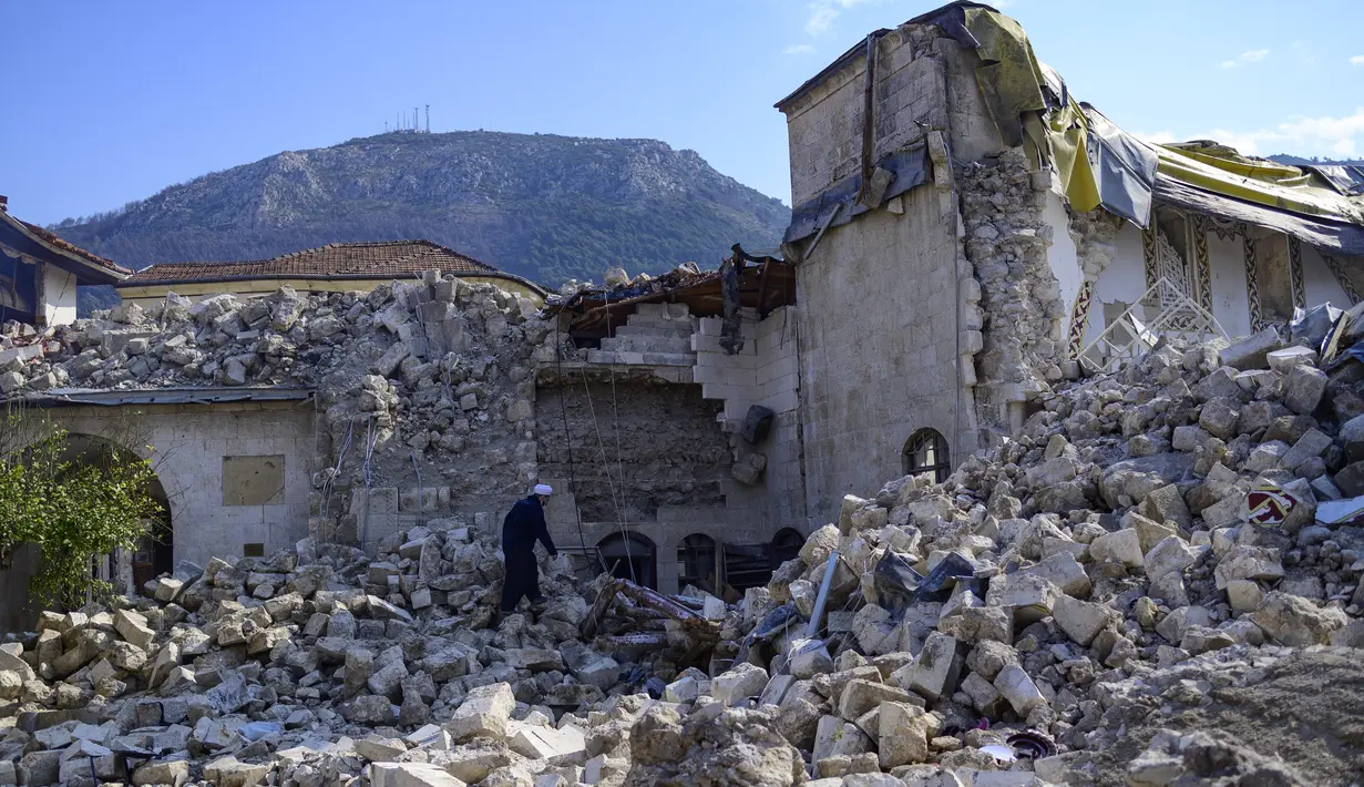 Seorang penduduk setempat memeriksa masjid Habib-i Neccar yang hancur di kota selatan bersejarah Antakya pada 11 Februari 2023, setelah gempa berkekuatan 7,8 melanda tenggara Turki. Masjid ini terletak di Antakya, salah satu kota yang paling parah terkena dampak di Turki. (Photo by Yasin AKGUL / AFP)