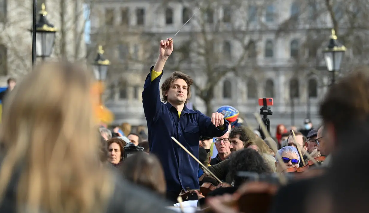 Puluhan musisi ambil bagian dalam pertunjukan flashmob "The Great Gate of Kyiv from pictures at an Exhibition" yang dipimpin seorang komposer Rusia-Inggris terkenal untuk menunjukkan dukungan terhadap Ukraina setelah invasi Rusia, di Trafalgar Square, London, Minggu (6/3/2022). (JUSTIN TALLIS/AFP)