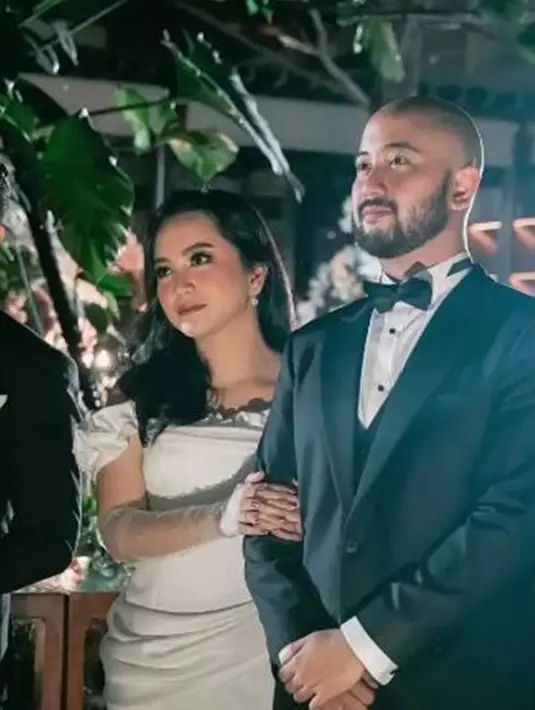 Di momen resepsi digelar lebih modern dan elegan. Masih dengan makeup flawless, Rachel Amanda terlihat begitu anggun di acara resepsinya. Mengusung konsep klasik putih hitam, membuat keduanya tampak begitu serasi. (Liputan6.com/IG/@imam_wibowo)