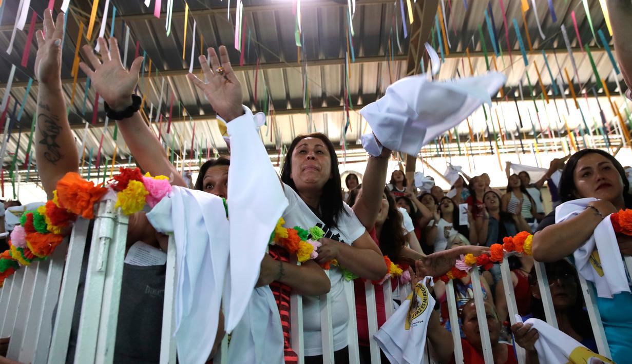 Sejumlah narapidana wanita melambaikan tangan saat menyambut kedatangan Paus Fransiskus di penjara wanita San Joaquin di Santiago, Chili (18/1). (AP Photo/Alessandra Tarantino/Pool)