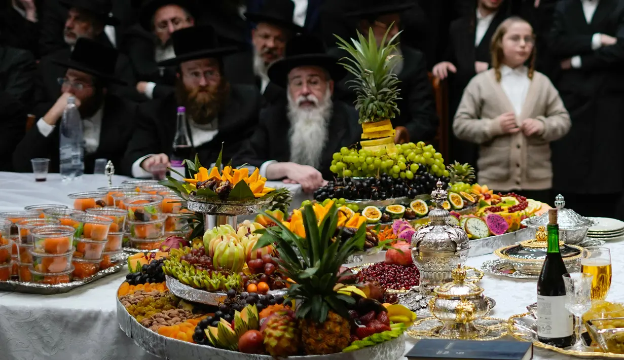 Orang-orang Yahudi Ultra-Ortodoks dari dinasti Hasid Sadigura merayakan Hari Raya Yahudi Tu Bishvat atau Tahun Baru Pohon di Yerusalem, 5 Februari 2023. Saat perayaan Tahun Baru Pohon, orang-orang Yahudi Ultra-Ortodoks berkumpul dengan para rabi mereka di sekitar meja panjang berisi piring-piring berisi beberapa jenis buah-buahan. (AP Photo/Ariel Schalit)