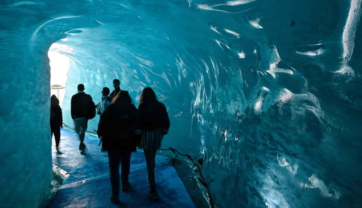 Wisatawan mengunjungi sebuah gua es yang dikenal dengan "La Grotte de Glace", di gletser Mer de Glace (Lautan Es) di Chamonix-Mont-Blanc, Pegunungan Alpen Prancis, Jumat (19/7/2019). Gua yang berada di lereng Mont Blanc ini memiliki panjang 7 km dengan kedalaman 200 meter. (PHILIPPE DESMAZES/AFP)