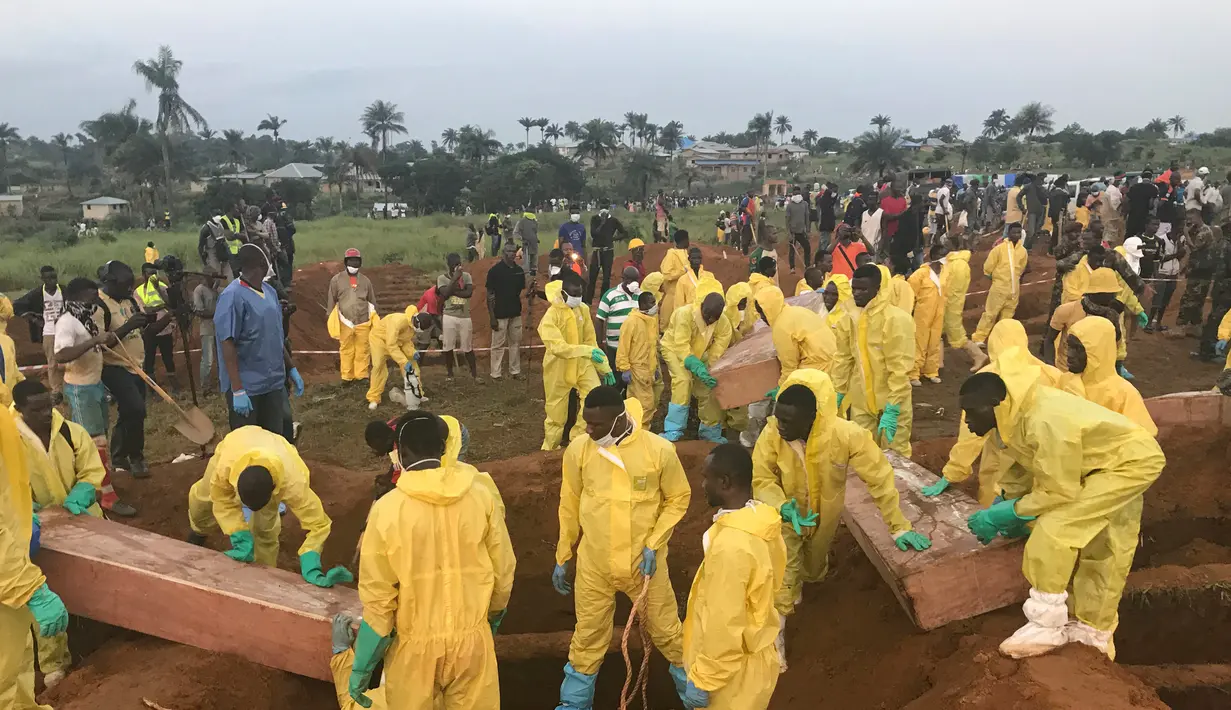 Sejumlah relawan saat memakamkan massal korban banjir dan tanah longsor di sebuah pemakaman di Sierra Leone, Freetown, (17/8). Pemerintah setempat telah mengubur 350 orang yang tewas akibat musibah tersebut. (AP Photo/Manika Kamara)