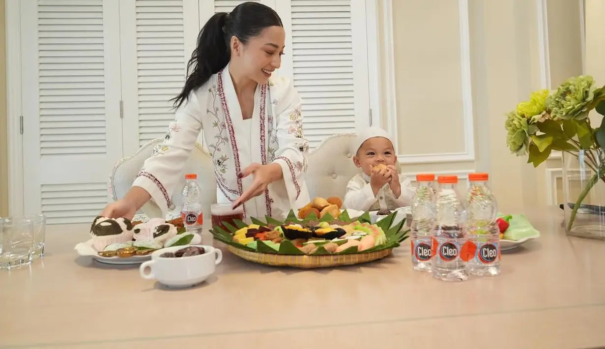 Di foto ini terlihat Nikita Willy sedang menyiapkan sajian makanan dengan senyum cantiknya memandang sang putra, yang keduanya kompak mengenakan busana serba putih. [Foto: Instagram/nikitawillyofficial94]