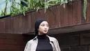 Bergaya layering dengan inner turtleneck hitam senada dengan kerudung turban dan belt mininya. Dipadukan outer kemeja oversize abu-abu dan celana denim panjang. [@ansellmaputri]
