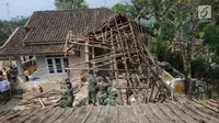 Anggota Yonif 320 Badak Putih Prajurit Jawara Kodam III Siliwangi membantu membersihkan reruntuhan bangunan usai gempa di Mandalawangi, Pandeglang, Banten, Sabtu (3/8/2019). Gempa Banten berkekuatan 6,9 magnitudo mengakibatkan lebih dari 200 rumah mengalami kerusakan. (merdeka.com/Arie Basuki)