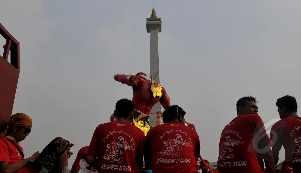 Sejumlah pemuda mengarak boneka raksasa dalam pawai Ogoh-ogoh di kawasan Monas, Jakarta, Jumat (20/3/2015). Pawai tersebut merupakan rangkaian dari prosesi menjelang Hari Raya Nyepi Tahun Saka 1937. (Liputan6.com/Johan Tallo)