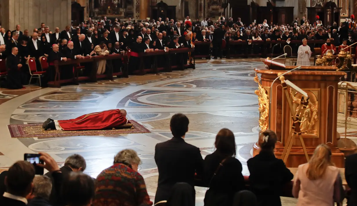 Paus Fransiskus berdoa sambil berbaring di lantai dalam prosesi Jumat Agung memperingati penyiksaan Yesus sebelum disalibkan di Basilika Santo Petrus, Vatikan, Jumat (19/4). (AP Photo/Alessandra Tarantino)