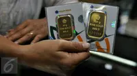 Pedagang menunjukan emas batangan 50 gram dan 100 gram di sebuah toko Kawasan Cikini, Jakarta, Kamis (3/9/2015). Harga emas milik PT Aneka Tambang Tbk (Antam) hari ini terpantau bergerak stabil di posisi Rp560 ribu per gram. (Liputan6.com/Johan Tallo)