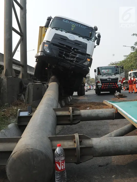 Kendaraan berat kontainer menabrak jalur pembatas pintu masuk tol akses Tanjung Priok di Jalan Raya Cilincing, Jakarta Utara, Sabtu (17/8/2019). Kejadian pada pukul 03.00 dini hari tadi terjadi akibat sopir mengantuk. Tidak ada korban jiwa dalam kejadian ini. (merdeka.com/Arie Basuki)