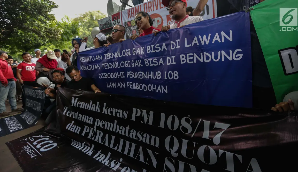 Puluhan driver online membentangkan spanduk saat unjuk rasa di depan Kementerian Perhubungan, Jakarta, Senin (22/1). Tarif juga harus dilakukan berdasarkan kesepakatan pengguna jasa dan penyedia jasa transportasi. (Liputan6.com/Faizal Fanani)