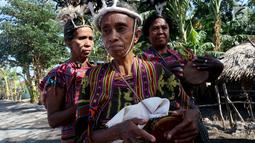 Sejumlah wanita memainkan alat musik tradisional dalam upacara peresmian bantuan bedah rumah di Desa Oebelo, NTT, Selasa (14/8). Upacara penyambutan diwarnai dengan tarian-tarian menggunakan alat musik baba khas daerah itu. (Liputan6.com/Johan Tallo)