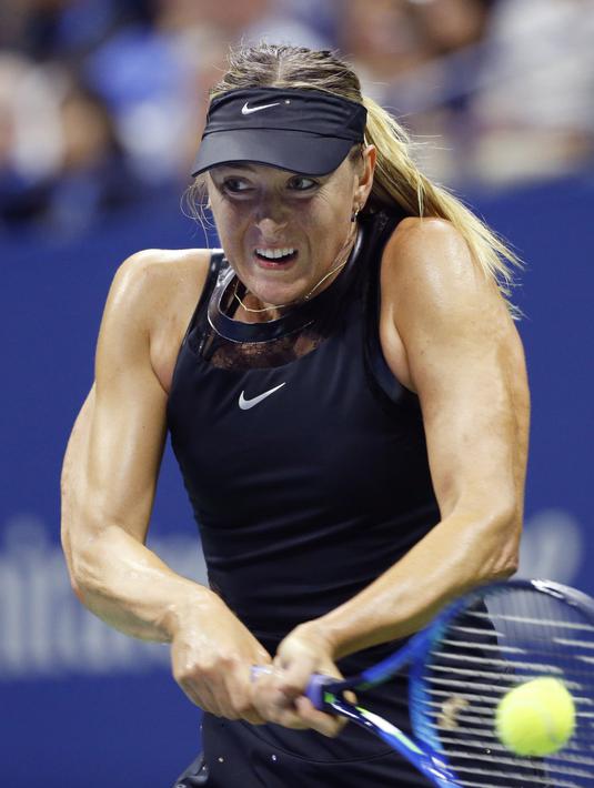 Otot kekar Maria Sharapova terlihat saat mengembalikan bola ke arah Simona Halep pada turnamen AS Terbuka 2017 di Stadion Arthur Ashe, New York (28/8/2017). Sharapova menang 6-4,4-6,6-3.  (AP/Kathy Willens)