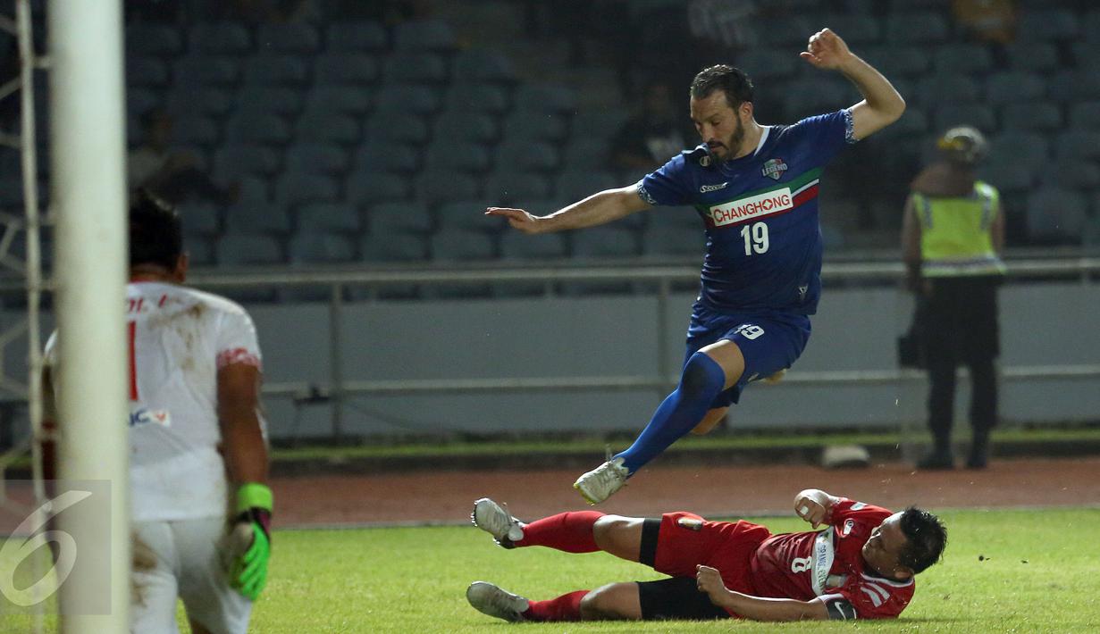 Gelandang Calcio Legend, Gianluca Zambrotta (atas) menghindari tekel pemain Primavera Baretti Irwan saat laga persahabatan di Stadion GBK Jakarta, Sabtu (21/5/2016). Calcio Legend menang telak 4-0. (Liputan6.com/Helmi Fithriansyah)