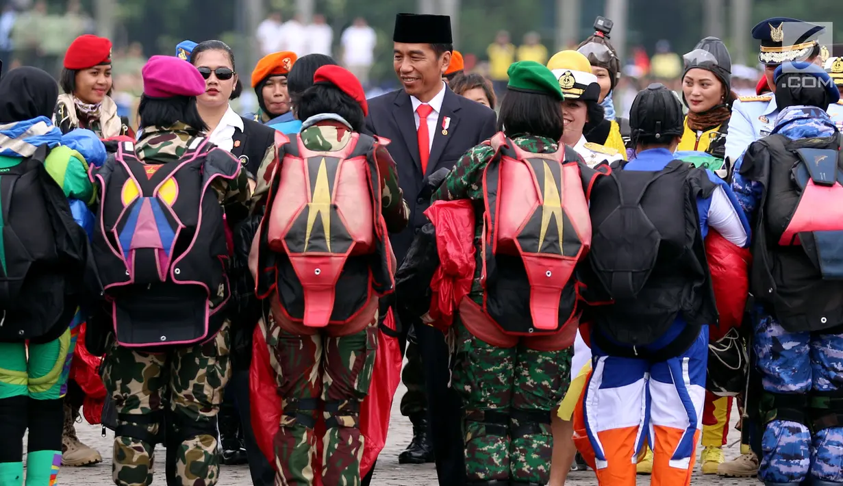 Presiden Jokowi menyapa penerjun wanita TNI seusai beratraksi pada upacara militer bersama Wanita TNI, Polwan dan Segenap Wanita Komponen Bangsa di Silang Monas Jakarta, Rabu (25/6). Upacara ini memperingati Hari Kartini 2018. (Liputan6.com/Johan Tallo)