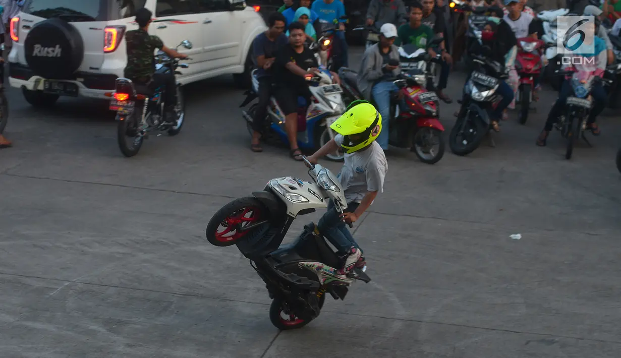 Seorang bikers beraksi di atas sepeda motornya di kawasan Kanal Banjir Timur, Jakarta, Selasa (29/5). Aksi berbahaya para rider di atas sepeda motor ini dilakukan pada saat ngabuburit menunggu bedug berbuka. (Merdeka.com/Imam Buhori)