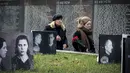 Orang-orang mengunjungi tugu peringatan bagi para korban represi politik di Butovo, di luar Moskow, pada Kamis 30 Oktober 2025, menandai hari peringatan. Peringatan ini sebagai pengingat akan kejahatan rezim Soviet dan penghormatan bagi para korban tewas dalam teror politik. Acara peringatan ini melibatkan keluarga dan kerabat korban yang berziarah ke lokasi tersebut. (Nikita BORISSOV/AFP)