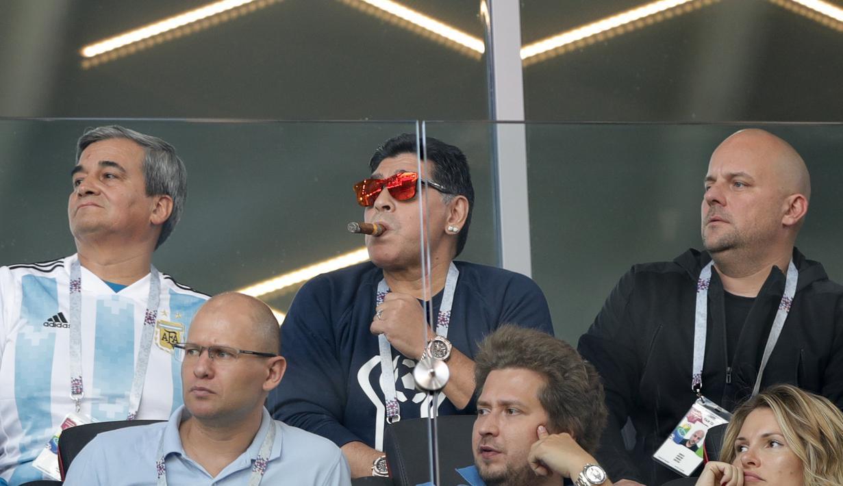 Diego Maradona menikmati sebatang Cerutu saat menyaksikan laga Argentina melawan Islandia di Spartak Stadium, Moskow (16/6/2018). FIFA melarang adanya asap rokok dan flare dalam stadion saat pelaksanaan Piala Dunia 2018. (AP/Ricardo Mazalan)