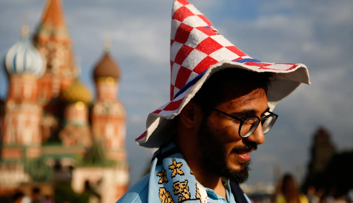 Seorang pria dari Palestina mengenakan topi yang menunjukkan dukungannya untuk tim Kroasia saat ia mengunjungi Lapangan Merah jelang final Piala Dunia 2018 antara Prancis melawan Kroasia di Moskow, Rusia, (13/7).  (AP Photo/Rebecca Blackwell)