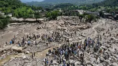 Pemandangan dari udara menunjukkan para korban banjir berkumpul di dekat rumah-rumah yang rusak di sepanjang tepi sungai yang dikelilingi batu-batu besar di distrik Buner, provinsi Khyber Pakhtunkhwa, Pakistan pada 17 Agustus 2025. (Abdul MAJEED/AFP)