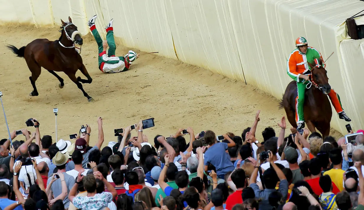 Seorang joki terjatuh saat beraksi dalam lomba pacuan kuda tahunan Palio di Siena, Italia. (Reuters/Fabio Muzzi)