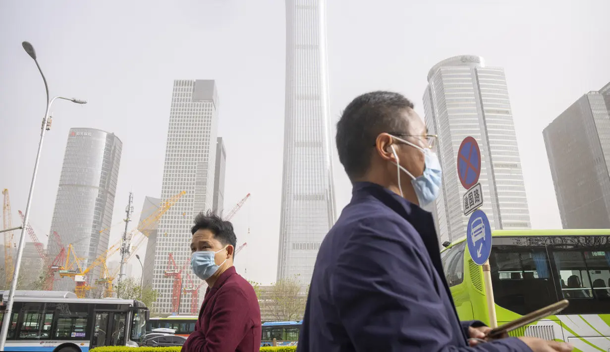 <p>Para komuter yang mengenakan masker berjalan saat badai debu dan pasir di kawasan pusat bisnis di Ibu Kota Beijing, China, Selasa (11/4/2023). Serangkaian badai debu dan pasir terbaru membuat indeks kualitas udara memburuk di Beijing pada Senin malam hingga Selasa. (AP Photo/Mark Schiefelbein)</p>