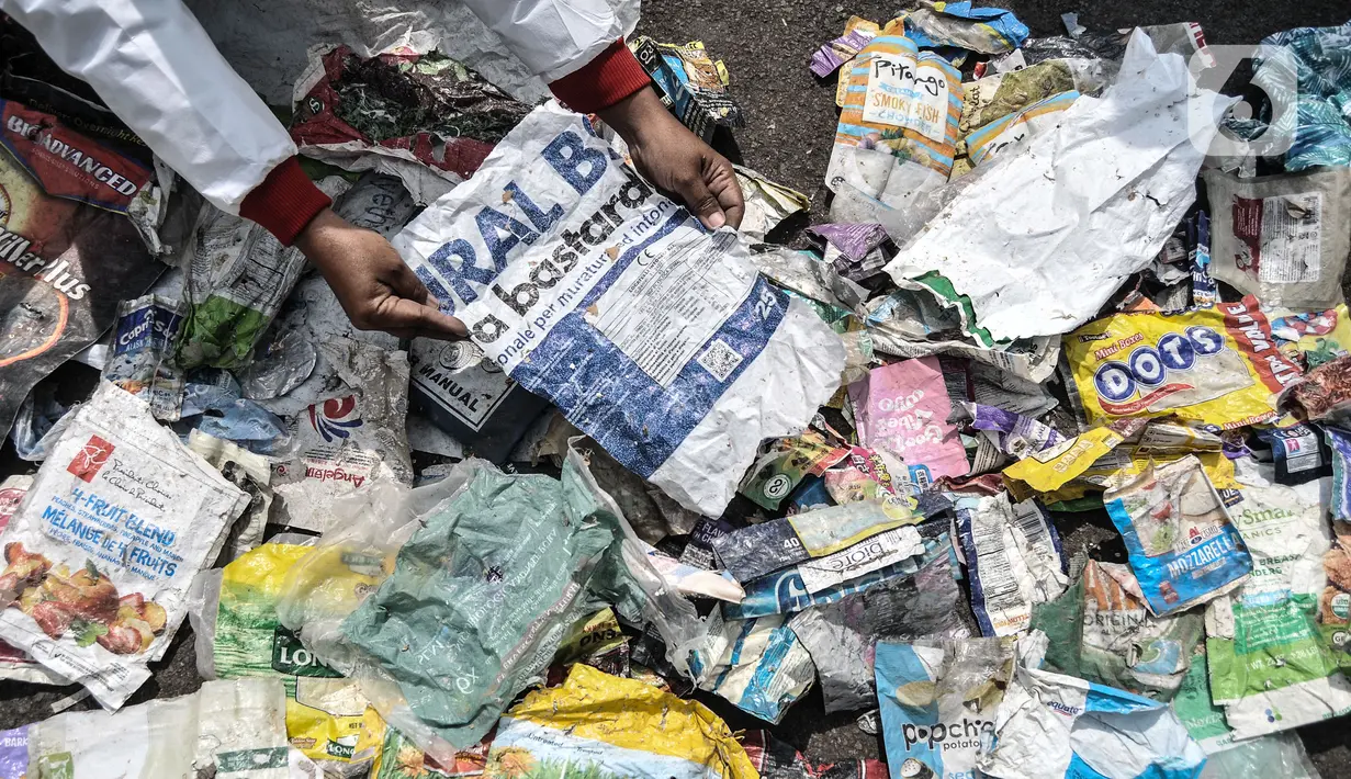 Aktivis menunjukkan limbah hasil temuan selama investigasi di daerah Sungai Brantas, Bengawan Solo, Citarum, dan Ciujung saat aksi "Sampah Impor Bunuh Sungai Pulau Jawa" di kawasan Patung Kuda, Monas, Jakarta, Senin (3/5/2021). (merdeka.com/Iqbal S. Nugroho)