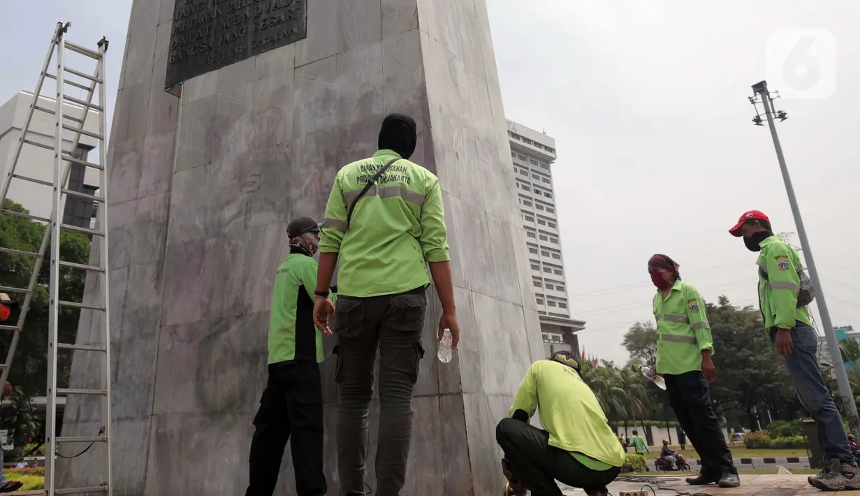 Petugas PPSU DKI Jakarta membersihkan coretan di kawasan Kebon Sirih, Jakarta Pusat, Sabtu (10/10/2020). Dinas kebersihan dari PPSU dan Satpel DLH melakukan penghapusan coretan di fasilitas umum oleh pengunjuk rasa saat demonstrasi tolak Omnibus Law UU Cipta Kerja. (Liputan6.com/Johan Tallo)