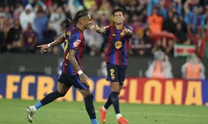 Penyerang Barcelona asal Brasil, Raphinha, merayakan gol keempat timnya bersama bek asal Portugal, Joao Cancelo, saat menghadapi Racing Santander pada pertandingan LaLiga di Stadion Camp Nou, Barcelona, Kamis (17/9/2026) dini hari WIB.  (Lluis Gene/AFP)