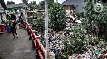 Kondisi tumpukan sampah yang memenuhi aliran Kali Baru, Jalan Raya Bogor, Cimanggis, Depok, Jawa Barat, Minggu (24/1/2021).  Menumpuknya sampah di perbatasan antara Jakarta dan Depok itu juga diperparah dengan kondisi sungai yang menyempit dan mengalami pedangkalan. (merdeka.com/Iqbal S. Nugroho)