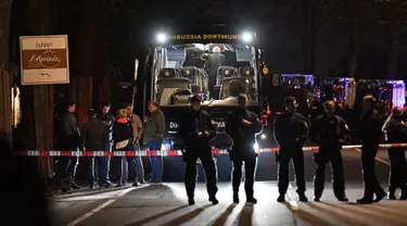 Polisi berjaga di depan bus tim Borussia Dortmund yang rusak terkena ledakan bom di Dortmund, Jerman Barat, Selasa (11/4). Bus membawa pemain Borussia Dortmund untuk pertandingan perempat final Liga Champions melawan Monaco. (AP Photo/Martin Meissner)