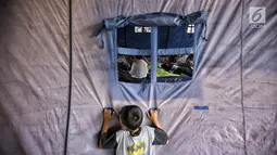 Seorang anak berada di luar tenda paska kebakaran di permukiman kumuh di RW 02 Kampung Walang, Lodan Raya, Jakarta, Minggu (25/8). Sebanyak 420 jiwa saat ini mengungsi pasca-kebakaran, di sebuah tenda darurat. (Liputan6.com/Faizal Fanani)