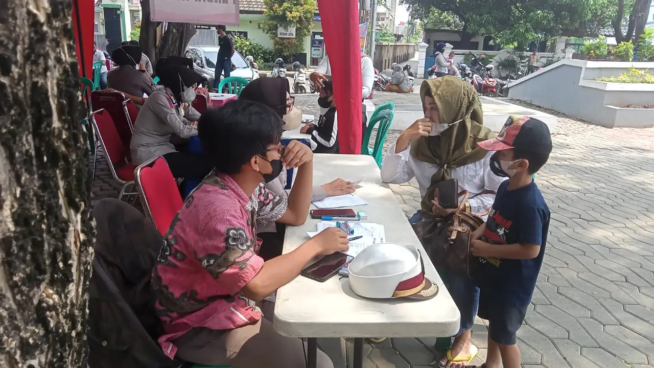 Warga Kota Bekasi antre mendapatkan vaksinasi yang digelar Polres Metro Bekasi Kota di Alun-alun M Hasibuan, Bekasi Selatan