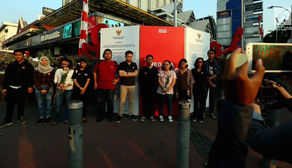 Aktivis Kontras berfoto bersama saat aksi di kawasan MH. Thamrin, Jakarta, Rabu (30/08). Aksi tersebut untuk mensosialisasikan jawaban dari negara terkait hasil penyelidikan penghilangan orang secara paksa periode 1997-1998. (Liputan6.com/Johan Tallo)