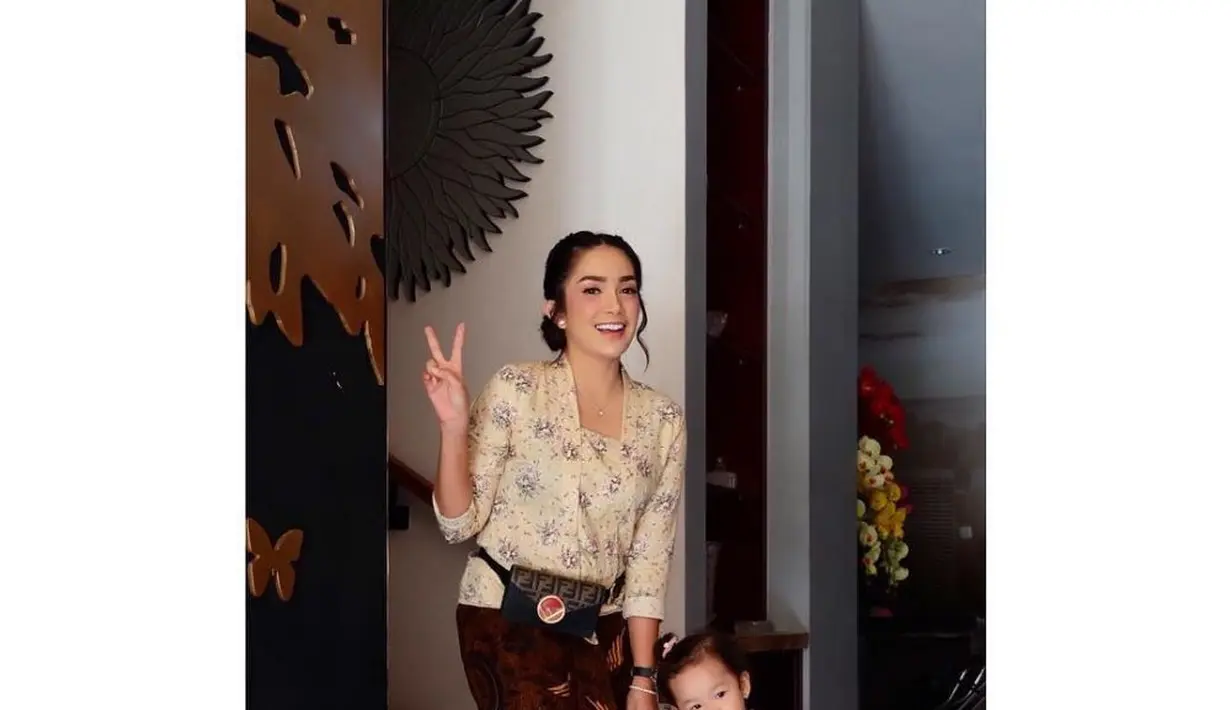 Ussy Sulistiawaty tampil kompak dengan si kecil mengenakan kebaya kutu baru coklat dipadukan kain batik dan sneakers putihnya. Instagram/@ussypratama