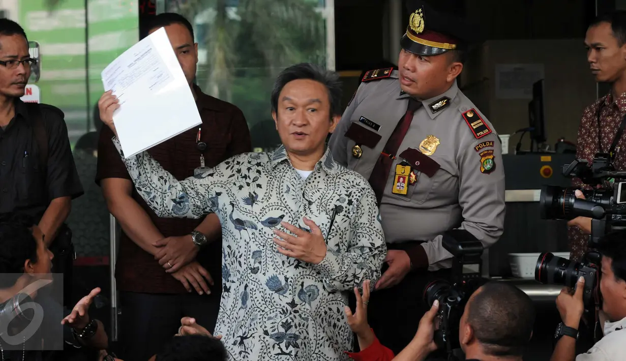 Kuasa hukum RJ Lino, Maqdir Ismail memperlihatkan surat pemberitahuan ketidakhadiran kliennya di Gedung KPK, Jakarta, Jumat (29/1). Mantan Dirut Pelindo II itu mangkir dari pemeriksaan karena sedang sakit. (Liputan6.com/Helmi Afandi)