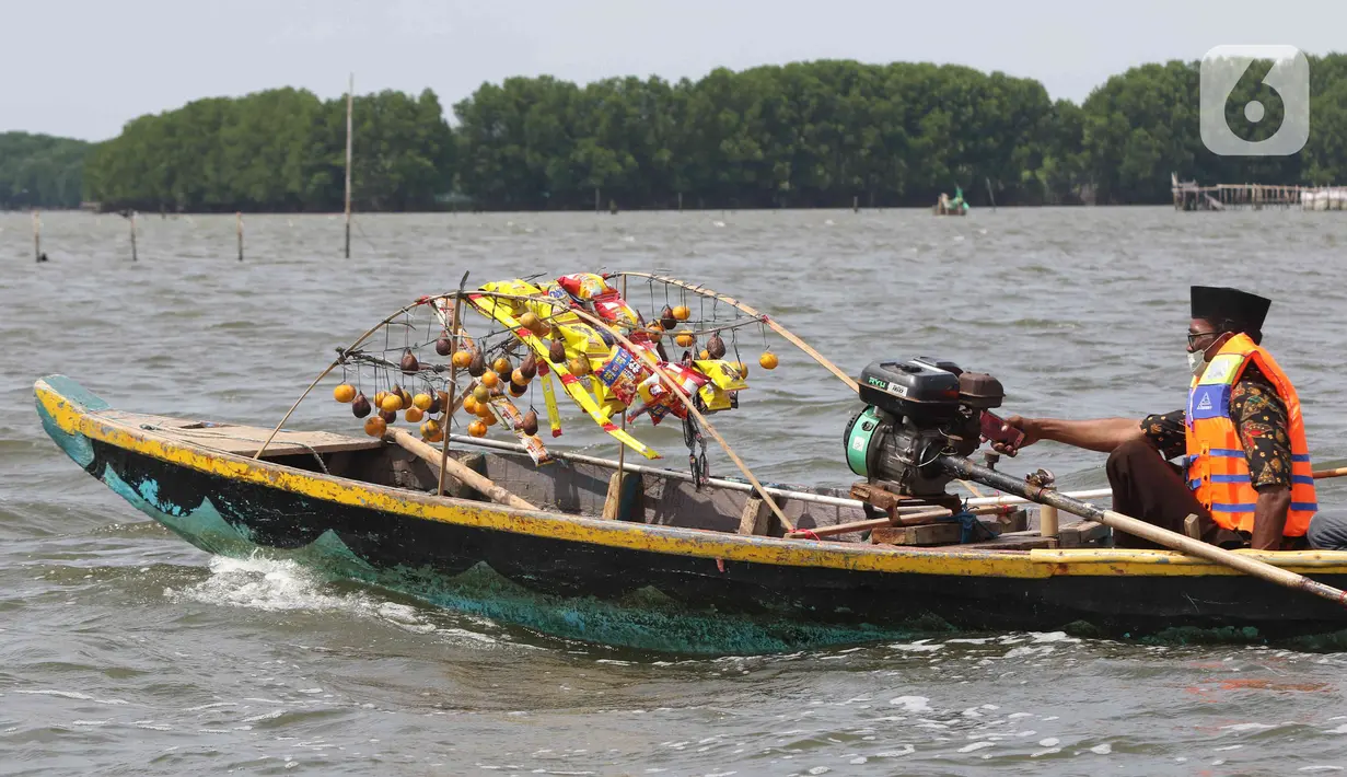 Seorang nelayan membawa sesaji di Pantai Tarumajaya, Kabupaten Bekasi, Jawa Barat, Jumat (28/1/2022). Ritual ini diikuti sebanyak 40 kapal nelayan dari enam Muara. (Liputan6.com/Herman Zakharia)
