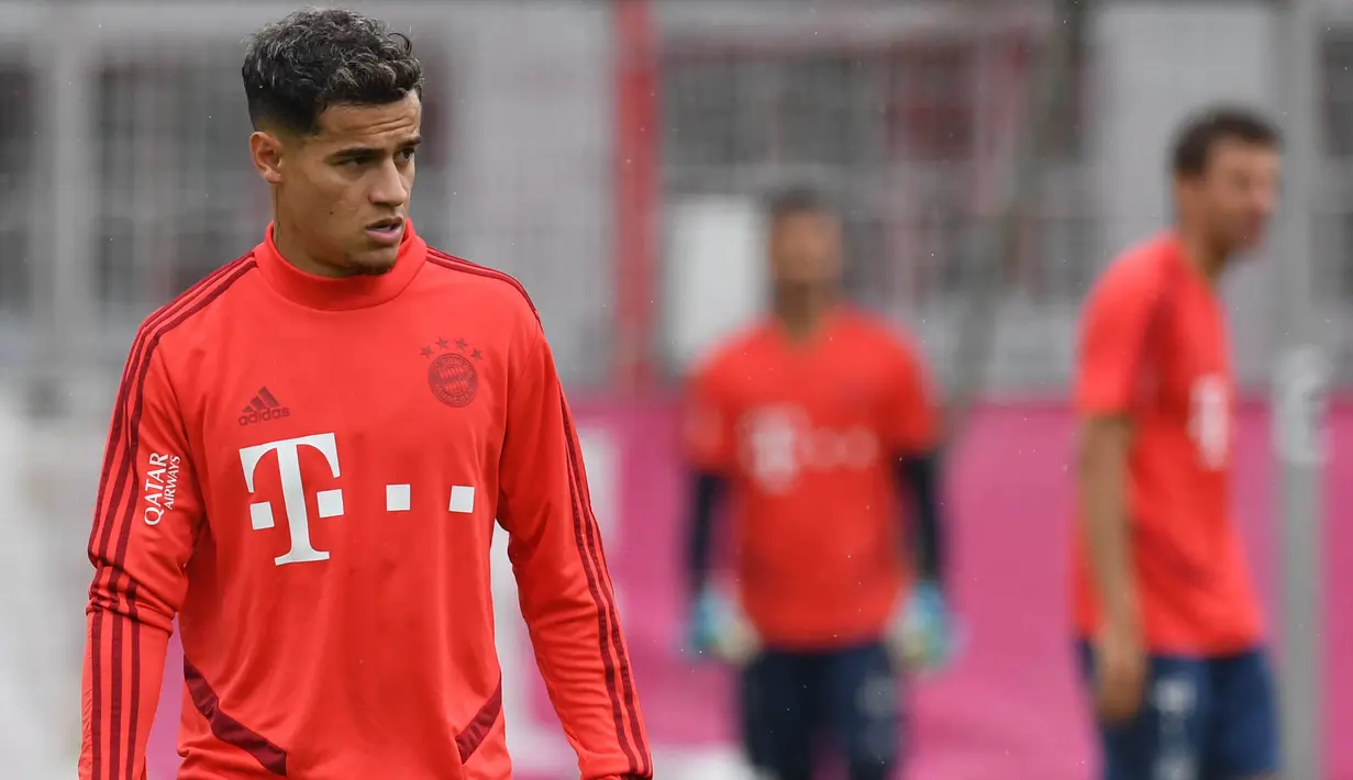 Pemain Bayern Munchen, Philippe Coutinho, mengamati instruksi saat latihan perdananya di Munchen, Selasa (20/8). Bintang Brasil ini didatangkan dari Barcelona. (AFP/Christof Stache)