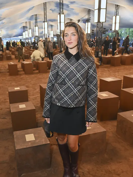 Adik Dua Lipa, Rina Lipa kenakan jaket kotak-kotak berkantung ganda dan rok mini. Dipadu dengan boots dan mini hang bag [Burberry]