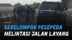 Sekelompok pesepeda terekam melintas  jalan layang yang di situ terdapat rambu larangan sepeda tidak boleh melintas.