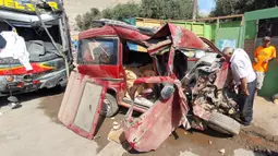 Seorang pria mengamati kondisi sebuah minivan yang ditabrak bus tingkat di daerah Arequipa, Peru, Senin (6/1/2020). Saat ini pihak operator bus masih melakukan investigasi terhadap kecelakaan maut itu. (Photo by Javier Casimiro / AFP)