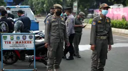 Petugas Satpol PP melakukan razia masker di depan Stasiun Klender, Jakarta, Selasa (10/5/2022). Untuk pemberlakuan pembatasan kegiatan masyarakat (PPKM) Jawa-Bali diperpanjang hingga 23 Mei 2022. (Liputan6.com/Faizal Fanani)