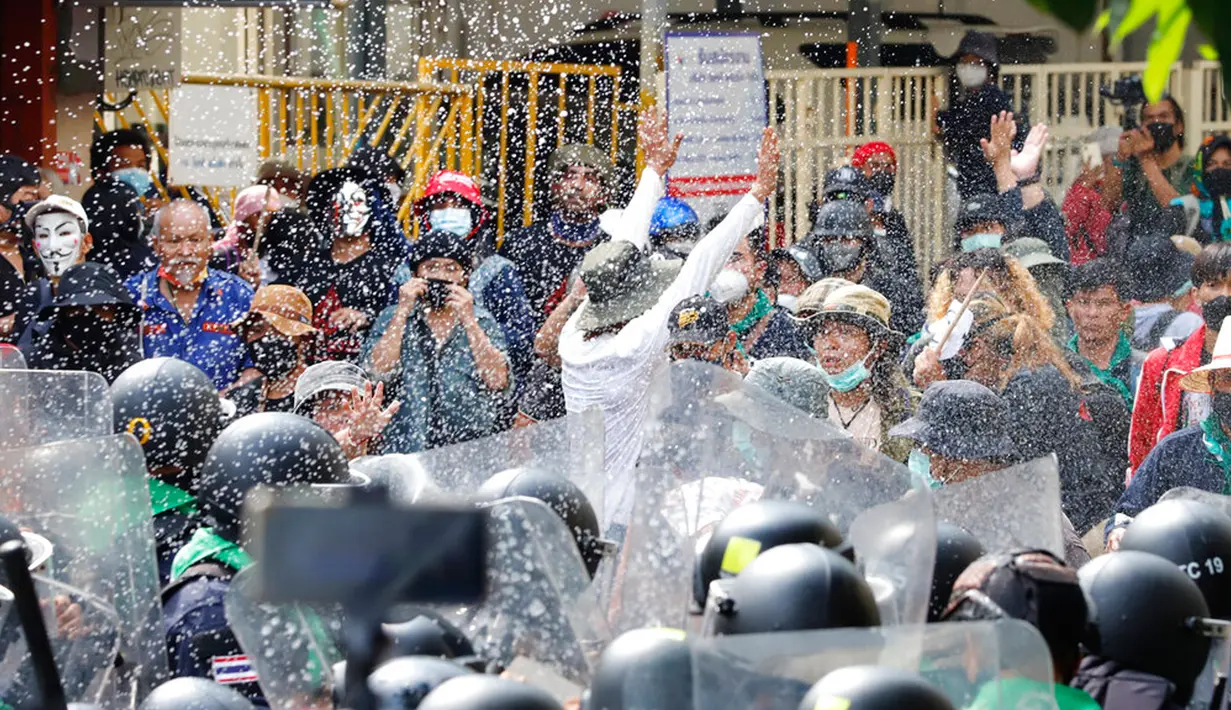 Pengunjuk rasa melemparkan kecap ikan fermentasi ke polisi antihuru-hara saat memprotes KTT APEC di Bangkok, Thailand, Jumat (18/11/2022). KTT APEC yang berlangsung pada tanggal 18-19 November 2022 diwarnai aksi unjuk rasa. (AP Photo/Sarot Meksophawannakul)