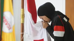 Pemain menyium bendera Merah Putih saat acara pelepasan Timnas Voli Putri Indonesia untuk mengikuti ajang AVC Nations Cup 2025 di Padepokan Bola Voli Jenderal Polisi Kunarto, Sentul, Bogor. Rabu (4/6/2025). (Bola.com/M Iqbal Ichsan)