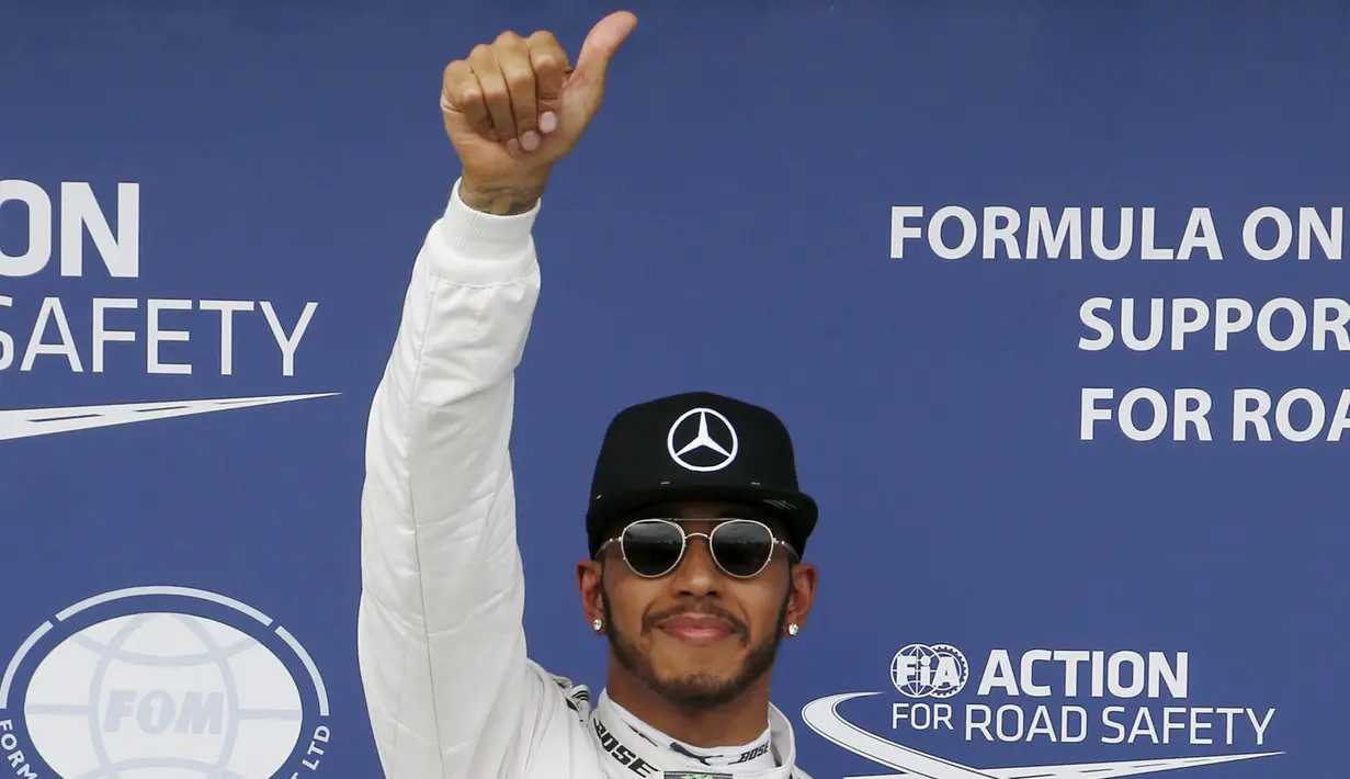 Pembalap Mercedes F1 Lewis Hamilton memberikan acungan jempol setelah kualifikasi di Australian Formula One Grand Prix di Melbourne (19/3). Juara F1 musim lalu itu mencatatkan waktu 1 menit 23,837 detik. (REUTERS/Brandon Malone)