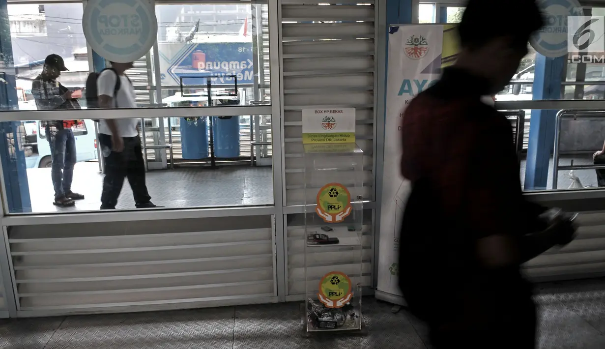 Penumpang melintasi kotak penampung sampah elektronik di Halte Transjakarta Kampung Melayu, Jakarta, Selasa (8/5). Sampah elektronik tersebut akan dikirim ke perusahaan pengelolah limbah bahan berbahaya beracun (B3). (Merdeka.com/Iqbal S. Nugroho)
